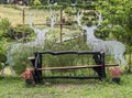 The lonely wooden bench in the flower garden and decorated by the deer standee