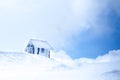 Lonely, wooden house covered with hoarfrost on top of the snowy mountain. Royalty Free Stock Photo