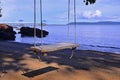 Lonely swing in sulight over sand beach Royalty Free Stock Photo