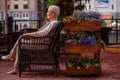 Lonely wwoman is sitting in the armchair at the cafe with beautiful flowers Royalty Free Stock Photo