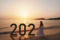 Lonely young asian woman standing on the beach at sunset with new year 2021 Royalty Free Stock Photo