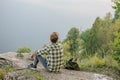 A lonely young man sits on the top of mountain Royalty Free Stock Photo