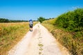A lonely walker with backpack along a countryside road in center Italy, June 2019