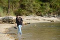 Lonely young woman in jeans walks barefoot on the beach