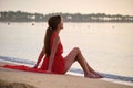 Lonely young woman sitting on ocean sandy beach by seaside enjoying warm tropical evening Royalty Free Stock Photo