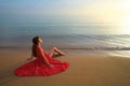 Lonely young woman sitting on ocean sandy beach by seaside enjoying warm tropical evening Royalty Free Stock Photo