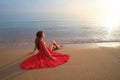 Lonely young woman sitting on ocean sandy beach by seaside enjoying warm tropical evening Royalty Free Stock Photo
