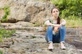 Lonely young woman sitting on rocks Royalty Free Stock Photo