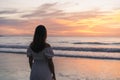 Lonely young woman standing on the beach at sunset Royalty Free Stock Photo