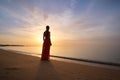 Lonely young woman standing on ocean beach by seaside enjoying warm tropical evening Royalty Free Stock Photo