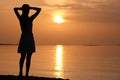 Lonely young woman standing on ocean beach by seaside enjoying warm tropical evening Royalty Free Stock Photo