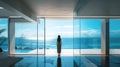 Lonely young woman stands at luxury home interior and looks at sea behind window, person and stunning amazing view from apartment Royalty Free Stock Photo