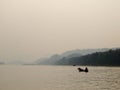 Lonesome scene of fisherman on old boat with landscape seascape estuary panorama view Royalty Free Stock Photo