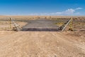 Loney desert farmland road in New Mexico, featuring a cattle guard Royalty Free Stock Photo