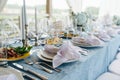 Long abundant table set for an event on a terrace. Empty plates and glasses