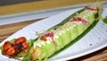 Long Avocado roll filled with tuna. unagi, tamago, cucumber pickle sushi roll with teriyaki sauce on white plate Royalty Free Stock Photo