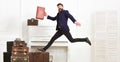 Long awaited vacation concept. Macho attractive, elegant on cheerful face carries vintage suitcases, jumping. Man with