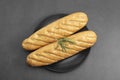 Long Baguette bread isolated on black dish, bread for sandwich. Top view Royalty Free Stock Photo