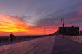 Long Beach, New York - December 13 2020 : Vibrant colorful sunset over people walking the boardwalk