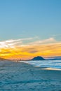 Long beach scene with landmark Mount Maunganui in distance