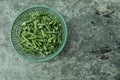long bean pieces in a green plastic container on a gray background. top angle. Royalty Free Stock Photo