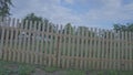Long beige wooden fence restrains territory in village area