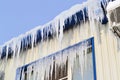 Long, big and dangerous icicles on a brick house roof Royalty Free Stock Photo