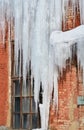 Long, big and dangerous icicles on a brick house roof Royalty Free Stock Photo