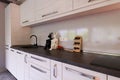 Long black countertop with sink and faucet on white kitchen cabinets Royalty Free Stock Photo