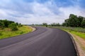 Long blank asphalt road with colorful green tree , grass on the side on blue sky background and white cloudy