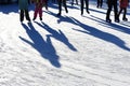 Long blue shadows on the ice at the ice rink from a group of skaters. Winter sunny day. Outdoor activities concept. Royalty Free Stock Photo