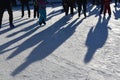 Long blue shadows on the ice at the ice rink from a group of skaters. Winter sunny day. Outdoor activities concept. Royalty Free Stock Photo