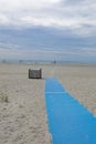 Long blue traction mat on beach sand allowing for handicapped access