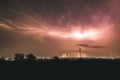 Long, branched, powerful lightning bolts strike down behind the trees. Dramatic lightning bolt. Royalty Free Stock Photo