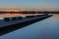 A long bridge with benches, beauty sunset over a calm lake