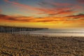 A long brown wooden pier with American flags flying on curved light posts with people walking and fishing on the pier Royalty Free Stock Photo