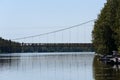 A long cable bridge over a sunny river Royalty Free Stock Photo