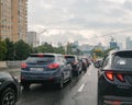 Long car traffic jam on a city street on a cloudy rainy summer day. Royalty Free Stock Photo