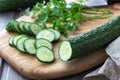 Long Chinese cucumbers on a cutting board while slicing salad. wood background