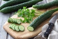 Long Chinese cucumbers on a cutting board while slicing salad. wood background