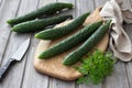 Long Chinese cucumbers laid out on a cutting board for slicing salad on the wooden background