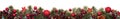 Long Christmas border banner of red ornaments and branches isolated on white Royalty Free Stock Photo
