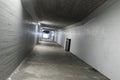 Long concrete pedestrian corridor that passes under the train station in Melide in Switzerland