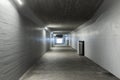 Long concrete pedestrian corridor that passes under the train station in Melide in Switzerland