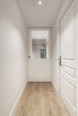 A long corridor of a house with a light wooden floor with access doors to the rooms Royalty Free Stock Photo