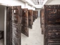 Long corridor with many open prison cell doors. Vintage image