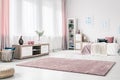 Long cozy rug on white wall of chic bedroom interior with wooden cabinet and wicker basket