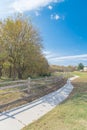 Long curved concrete pathway with rustic wooden fence and colorful fall foliage at park in Texas, USA Royalty Free Stock Photo