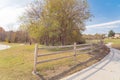 Long curved concrete pathway with rustic wooden fence and colorful fall foliage at park in Texas, USA Royalty Free Stock Photo