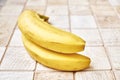 Two ripe bananas on a checkered wooden surface